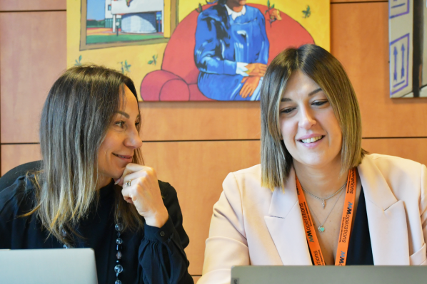 Professioniste MM Operations collaborano in ufficio, condividendo idee e competenze in un ambiente dinamico e positivo.